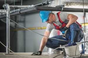 Caucasian HVAC Worker Wearing Safety Harness at Work